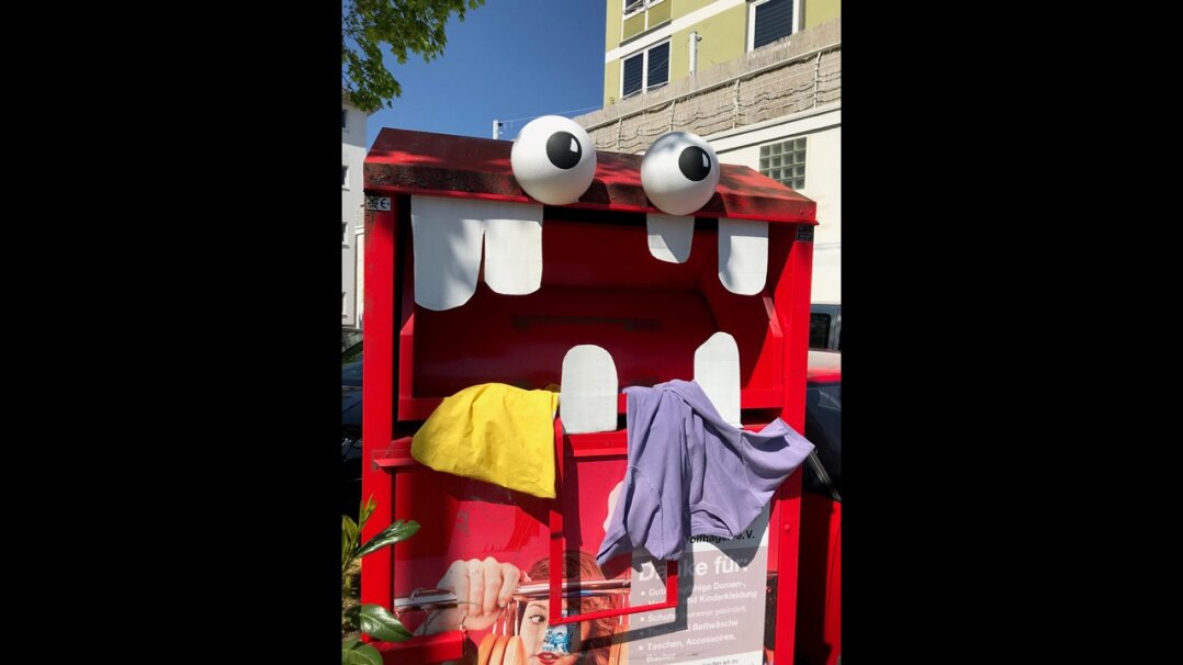 Fotografie eines überfütterten Kleidercontainer-Monsters